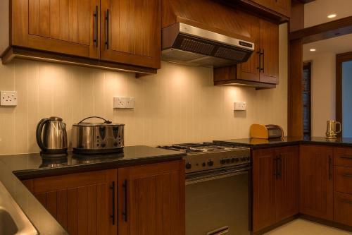 a kitchen with wooden cabinets and a stove top oven at Unique Towers Luxury Boutique Suites in Colombo