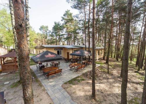 eine Draufsicht auf eine Terrasse mit Tischen und Sonnenschirmen in der Unterkunft Rzeka Miodu in Kałuże
