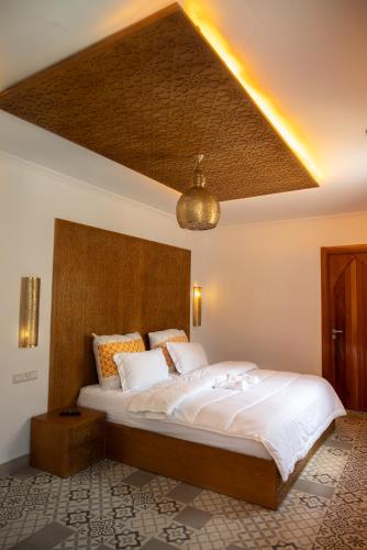 a bedroom with a large bed with a ceiling at Diyar Marhaba in Chefchaouen
