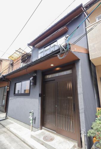a house with a brown door and a building at ZenKyoto in Kyoto