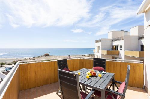 a table and chairs on a balcony with a view of the beach at Seafront Penthouse in El Medano in El Médano