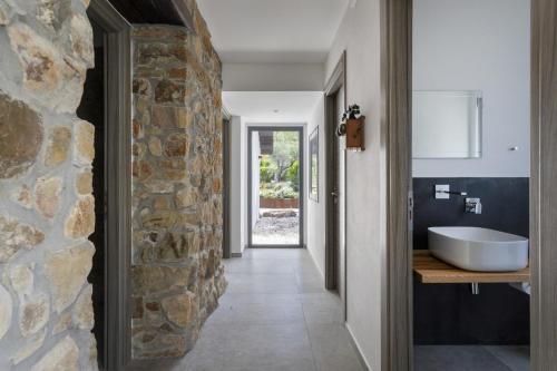 a bathroom with a stone wall and a sink at Villa Charme 6 by Massimo Villas in SantʼAmbrogio