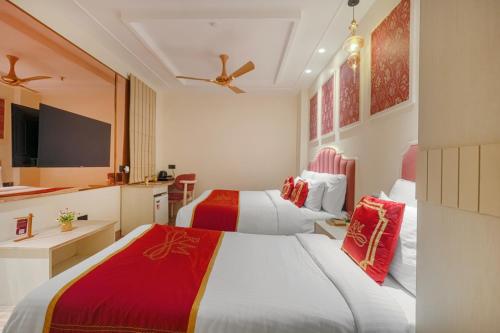 a hotel room with two beds and a tv at Hotel Red Martin 2 min walk from Golden Temple in Amritsar