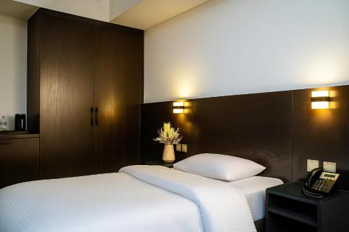 a hotel room with two beds and a telephone at Garden City Hotel Dubai in Dubai