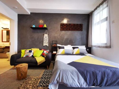 a bedroom with a bed and a couch at Studio 207 Ebene Square Apartments in Quatre Bornes