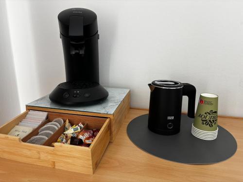 a black coffee maker next to a box of cookies at Pension Ingrid in Neutal