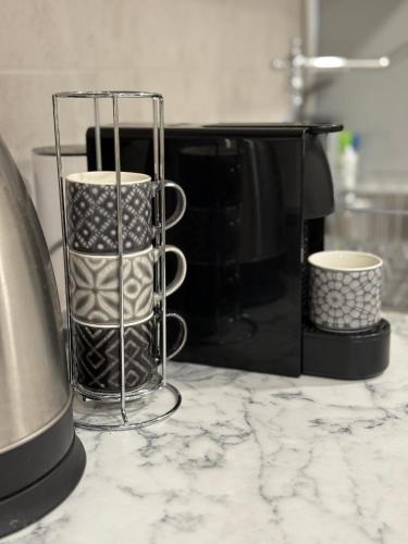 a counter with two coffee cups and a microwave at Apartment Zdravets 2, in the heart of the old city in Veliko Tŭrnovo