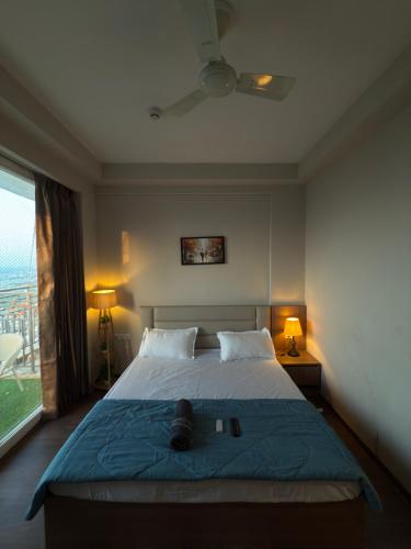 Un dormitorio con una cama con una manta azul y una ventana. en Visitor stop, en Greater Noida