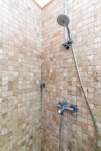 a shower with a shower head in a bathroom at Naro Suites Çeşme Marina in Çeşme