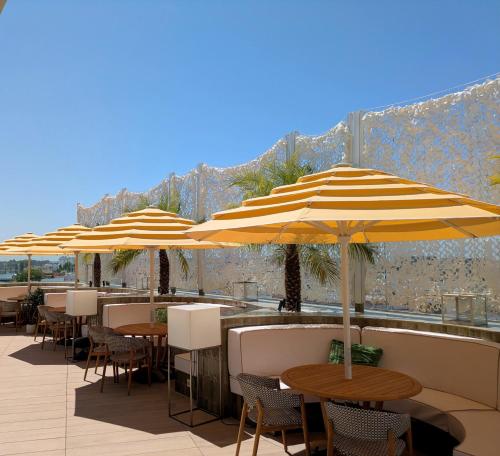 a row of tables and umbrellas on a patio at Ribera de Triana Hotel in Seville