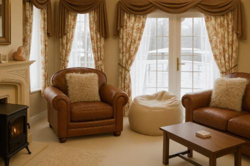 un soggiorno con due sedie e un camino di Combe Haven Holiday Park - Holiday Accommodation 12122 a Hollington