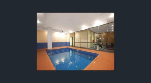 a large swimming pool in the middle of a house at Minimalist 2-Bed, 2-Bath Apartment in Melbourne CBD - Free Parking in Melbourne