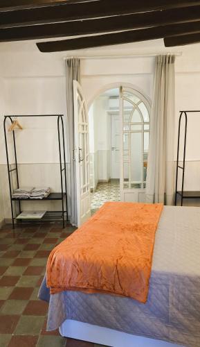 a bedroom with a large bed with an orange blanket at Moöm Apartamentos Turísticos in Tíjola