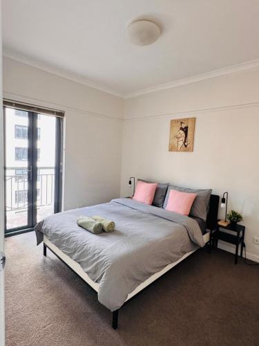 a bedroom with a large bed and a large window at Minimalist 2-Bed, 2-Bath Apartment in Melbourne CBD - Free Parking in Melbourne