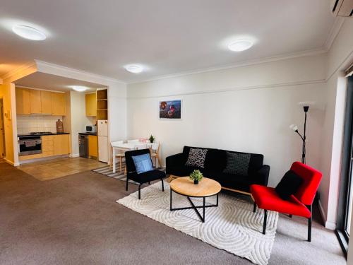 a living room with a couch and chairs and a table at Minimalist 2-Bed, 2-Bath Apartment in Melbourne CBD - Free Parking in Melbourne
