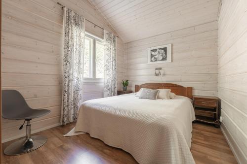 a bedroom with a bed and a chair and a window at Karkutahko Villas 1A - Spacious 3BR Villa in Tahko with Private Sauna in Ruokonen