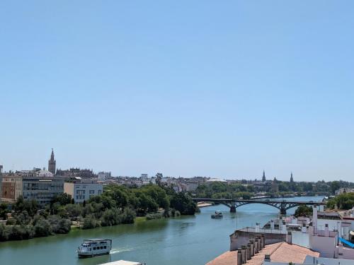 a view of a river with a bridge at Ribera de Triana Hotel in Seville