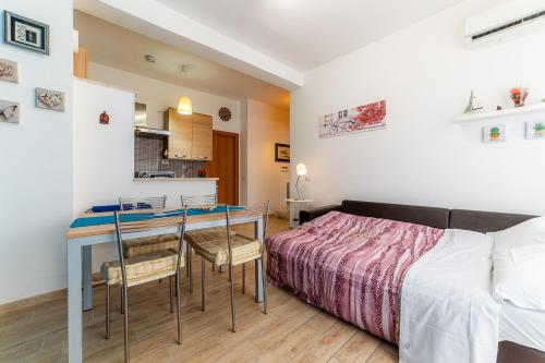 a bedroom with a bed and a table with chairs at Sea View Flat - close to the Beach and Fiumicino Airport in Isola Sacra