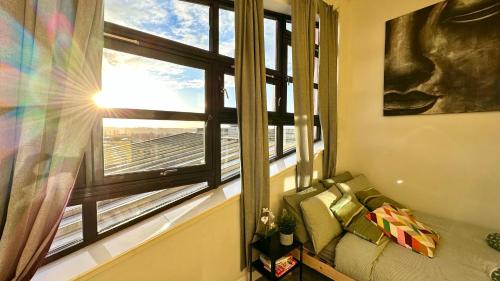 a room with a window with a couch in front of it at Sunny day new flat with 5 beds in Clydebank