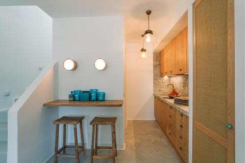 a small kitchen with two stools and a counter at Turquoise in Platis Yialos Sifnos