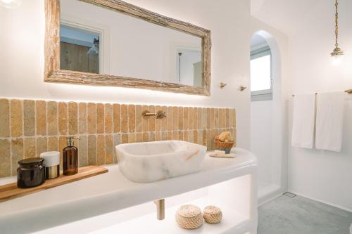 a white bathroom with a sink and a mirror at Turquoise in Platis Yialos Sifnos