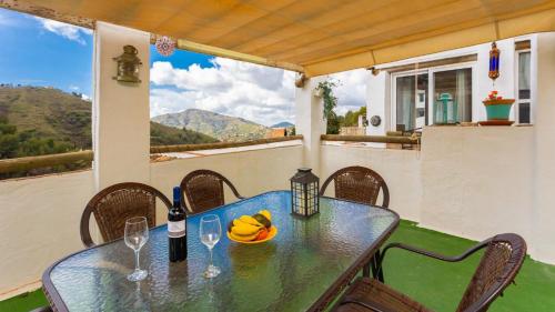 AcebuchalHeated pool villa - El Acebuchal的阳台上配有带葡萄酒瓶和玻璃杯的桌子