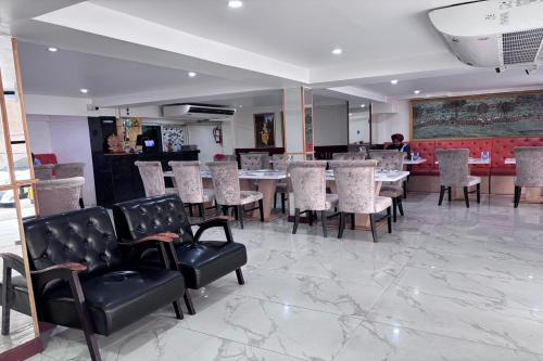 Un comedor con mesas y sillas en un restaurante. en Papa Ji Hotel and Restaurant, en Bangkok