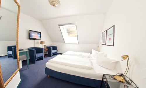 a hotel room with a bed and a desk and chairs at Waldhaus an de Miälkwellen in Ladbergen
