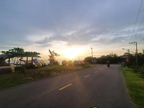 a person riding a motorcycle down a road at sunset at Orange Beach House in Phú Quí (2)