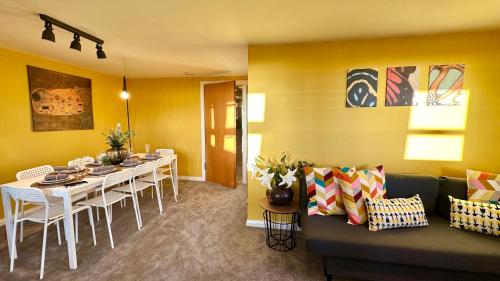 a living room with a couch and a dining room at Sunny day new flat with 5 beds in Clydebank