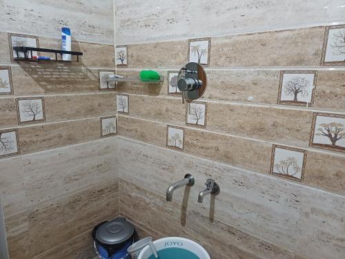 y baño con ducha y 2 grifos. en Èclairs Homestay, en Madikeri