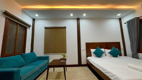 a hotel room with a bed and a couch at Siem Reap Heritage Wooden House in Siem Reap