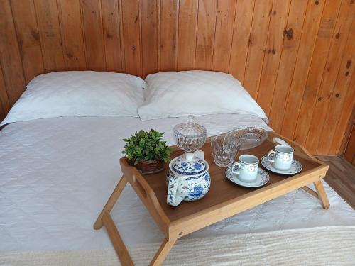 a bed with a table with tea sets on it at Recanto Doce Lar in Passo De Torres