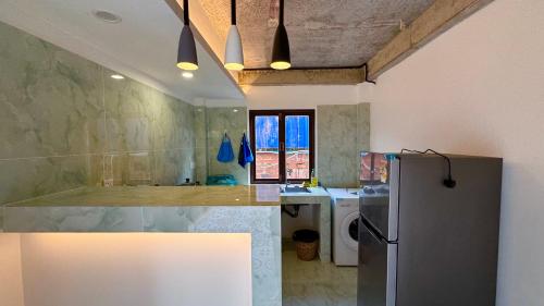 a kitchen with a refrigerator and a sink at Sala Khmer Heritage - Siem Reap Traditional Wooden House in Siem Reap