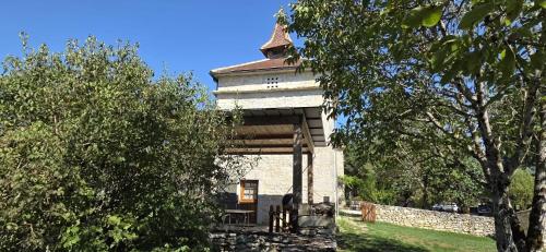 a building with a tower on top of a field at Domaine de Fangal, Pgeonnier 2p, maison 8p - piscine 25m - gîtes climatisés in Septfonds