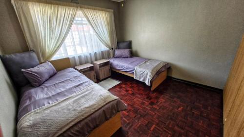 a room with two beds and a window at House Accommodation in Sasolburg