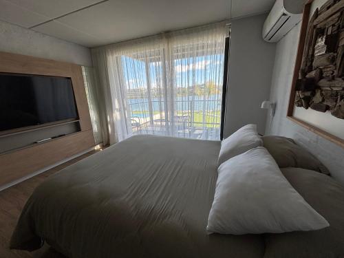 a bedroom with a large bed and a large window at Excepcional Monoambiente edificio LAWA Calyptus in Montevideo