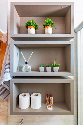 a shelf with toilet paper and plants in it at Apto com Ar e varanda a 5 min do aeroporto in Brasilia