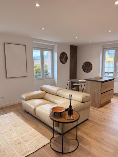 a living room with a couch and a table at Vue imprenable - Place de la République in Belfort