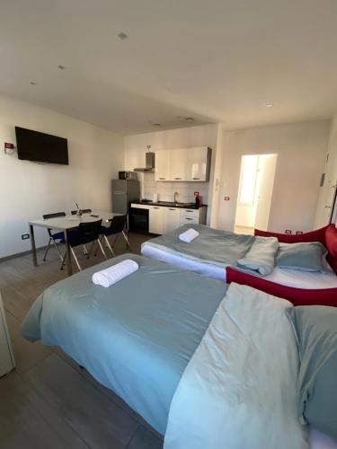 two large beds in a room with a kitchen at La Casa di Anna in Delebio