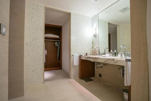 a bathroom with two sinks and a large mirror at Oryx Airport Hotel -Transit Only in Doha
