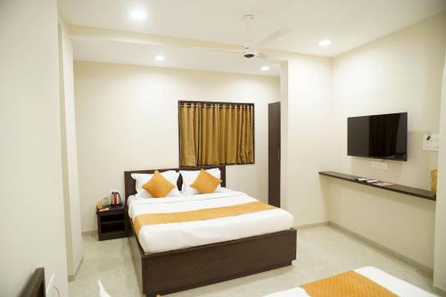 Una cama o camas en una habitación de Hotel Visawa Residency