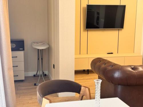 a living room with a couch and a tv on a cabinet at Premium Delux Astana in Zhezdi