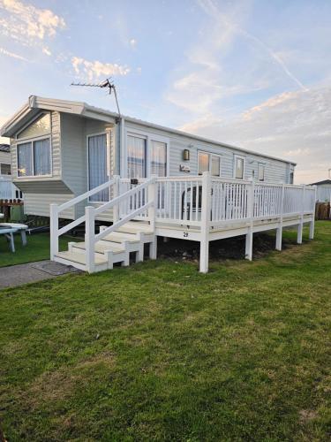 a mobile home with a porch and a white railing at 211 Holiday Resort Unity 6 berth Passes Optional No Pets in Brean