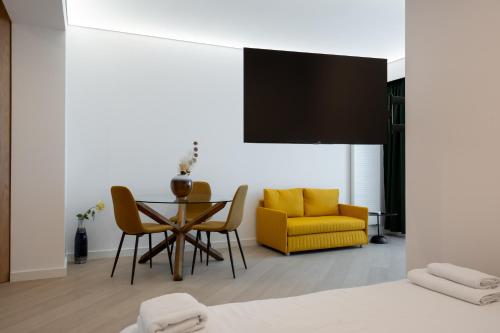 ein Wohnzimmer mit einem Tisch und einem gelben Stuhl in der Unterkunft Elegant Studio Cortina Modern Stay in Voluntari