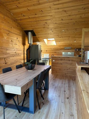 ein hölzernes Esszimmer mit einem Holztisch und Stühlen in der Unterkunft MAISON Style CHALET in Montfroc