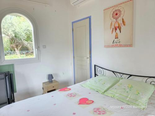 a bedroom with a white bed with hearts on it at LE BARCARES Maison pour 3 personnes Casa para 3 personas House for 3 people in Le Barcarès