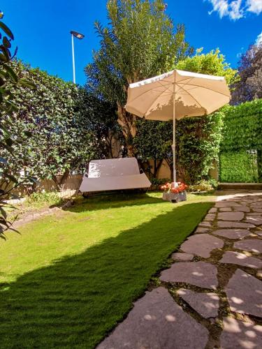 a patio with an umbrella and green grass at Apt tra arte e natura ingresso indipendente in Florence