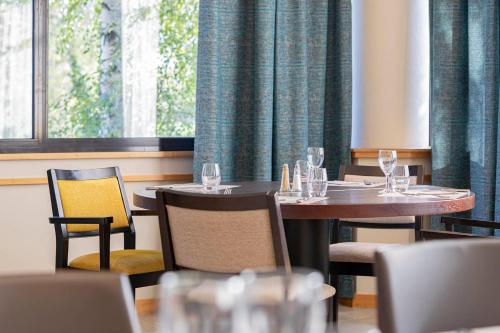 a restaurant with two tables and chairs and a window at Logis Lyon Est Porte de l'Ain in Saint-Maurice-de-Beynost