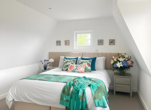 a bedroom with a large white bed with colorful pillows at Seahorse in Sark